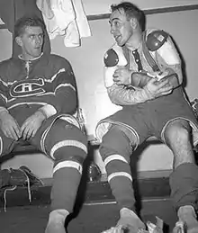 Photo de Toe Blake et Maurice Richard qui discutent assis sur un banc dans un vestiaire.