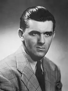 Portrait-photo en noir et blanc de Maurice Richard en costume avec une cravate