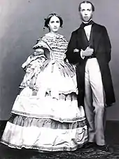 photographie représentant Charlotte en robe à crinoline au bras de Maximilien en habit civil