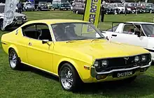 Une voiture de sport jaune en exposition à l'extérieur.