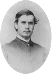 Photographie d'un homme avec la raie sur le côté portant une chemise d'uniforme
