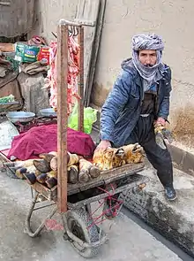 Boucher ambulant à Kaboul, proposant de la chèvre.