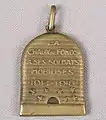 Médaille pendentif en laiton en forme de ruche. Ce souvenir de mobilisation des soldats chaux-de-fonniers pendant la Première guerre mondiale, comporte également des abeilles, symboles des habitants la Ville.