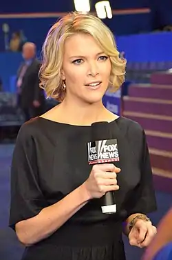 Une femme blonde tenant un microphone Fox News pendant qu'elle est filmée.