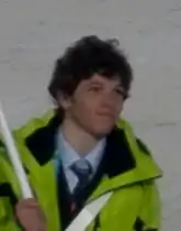 Portrait en buste d'un jeune homme portant un manteau vert clair.