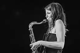 photo noir et blanc d'une femme jouant du saxophone ténor