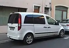 Photo d'une voiture blanche vue de trois-quart arrière dans une rue.