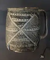 Une photo couleur d'un récipient en poterie noir sur blanc