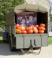 Un camion militaire de la Seconde Guerre mondiale rempli de citrouilles, affichant une photo agrandie de Louis de Funès et Bourvil dans La Grande Vadrouille.