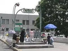 Photo couleur d'une balustrade en fer forgé avec portique complet et des gens autour