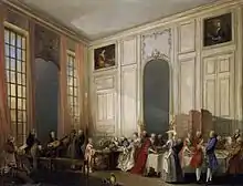 peinture : un salon au très haut plafond et ses invités ; Mozart est à gauche au clavecin.