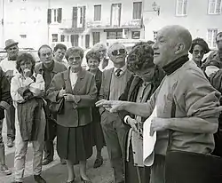 Sacoche en bandoulière, manches retroussées, document en main : Michel Bouillot lors d'une visite de Lugny.