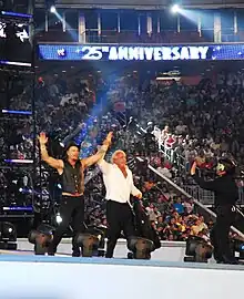Photographie de Mickey Rourke et Ric Flair saluant la foule au spectacle de catch Wrestlemania 25.