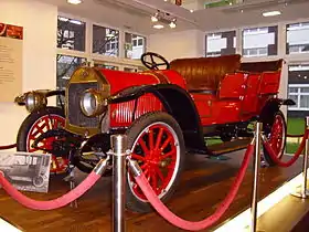 Photographie montrant une voiture cabriolet de 1913, de couleur rouge vif.