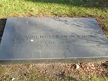 Photographie en couleur d’une plaque de tombe.