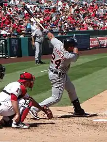 Photographie d'un match de baseball lors duquel un joueur termine son swing.