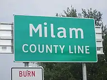 Panneau vert de signalisation routière avec inscription Milan County Line