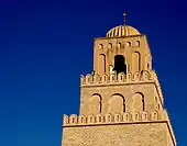 Vue de la partie supérieure du minaret. Les deuxième et troisième niveaux sont protégés par un parapet aux merlons arrondis, lesquels sont percés d'ouvertures en forme de meurtrières.