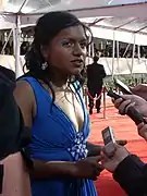 Photo d'une femme habillée d'une robe bleue en pleine interview lors d'un gala.