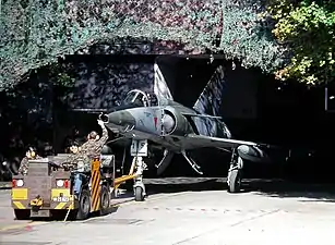 Un Mirage IIIRS tracté hors d'une caverne pour avion (en) à Buochs en 1999.