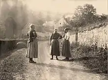 Femmes parlant sur une route de campagne.