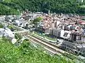 Vue de la ligne à sa sortie de la gare de Moûtiers à droite, en direction de Bourg-Saint-Maurice, avant le tunnel de la Boucle à gauche.