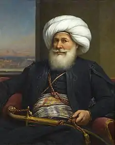 Tableau représentant un homme à l'abondante barbe blanche, portant un turban et ayant un poignard posé sur ses genoux.