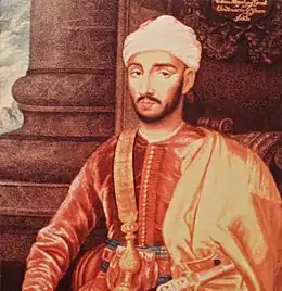 Tableau représentant un homme habillé en rouge portant une barbe fine et un turban.
