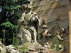 Le monument envahi par les plantes, détail du Christ et des soldats.