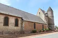 Vue latérale côté rue de l'église qui montre la hauteur de la première partie de le nef sur laquelle s'appuient les tours.