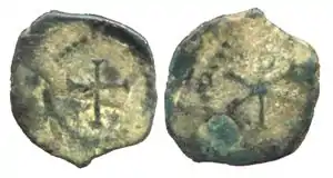 Monnaie de cuivre attribuée à Childebert Ier (511-558). Avers : Chrisme dans une guirlande.Revers : Croix dans une guirlande.