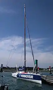 Vue de trois quarts avant, voilier bleu et blanc amarré au ponton.