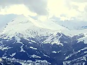 Paysage hivernal du mont Joly (à gauche dans les nuages) avec à ses pieds à droite sur la crête la Croix du Christ au-dessus de Saint-Gervais-les-Bains.