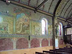 Photographie en couleurs de murs entièrement recouverts de peintures religieuses.