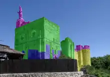 Photographie retouchée montrant par un jeu de couleurs les différents états d'un groupe d'édifices.
