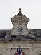 Photographie en couleurs du cadran d'un horloge au sommet d'un toit.