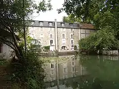 Photographie en couleurs d'un long bâtiment qui semble posé sur l'eau.