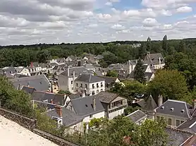 Photographie en couleurs de maisons dans une vallée au milieu d'arbres.