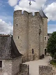 Photographie en couleurs d'un ensemble de bâtiments accolés, dont une tour à l'aspect médiéval.