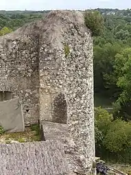 Photographie en couleurs des vestiges d'une tour à l'angle de deux murs.