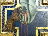 Détail : saint François d'Assise baise les pieds du Christ.