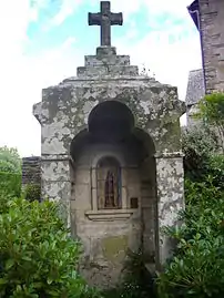 La fontaine représentant Saint Laur, derrière l'église.