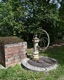 Ancienne fontaine à manivelle sur le parvis de l'église de Montesquieu.