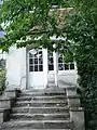 Porte blanche vitrée en haut d'un escalier en pierre de taille