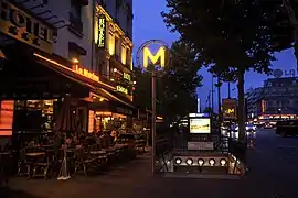 Une entrée de la station, le soir, sur le boulevard du Montparnasse.