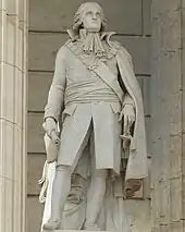 Statue en pierre blanche d'un homme en tenue d'apparat.