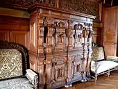 Vue d'un meuble pourvu de nombreuses portes et tiroirs, dont certains secrets ou à mécanisme.