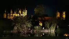 Photographie nocturne en couleurs d'un château illuminé.