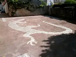 Photographie en couleurs d'une mosaïque au sol représentant un lézard.