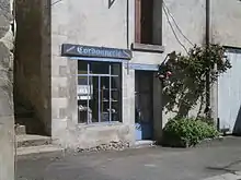 Photographie en couleurs d'un ancien magasin dont la devanture porte l'inscription : « Cordonnerie, galoches, sabots ».